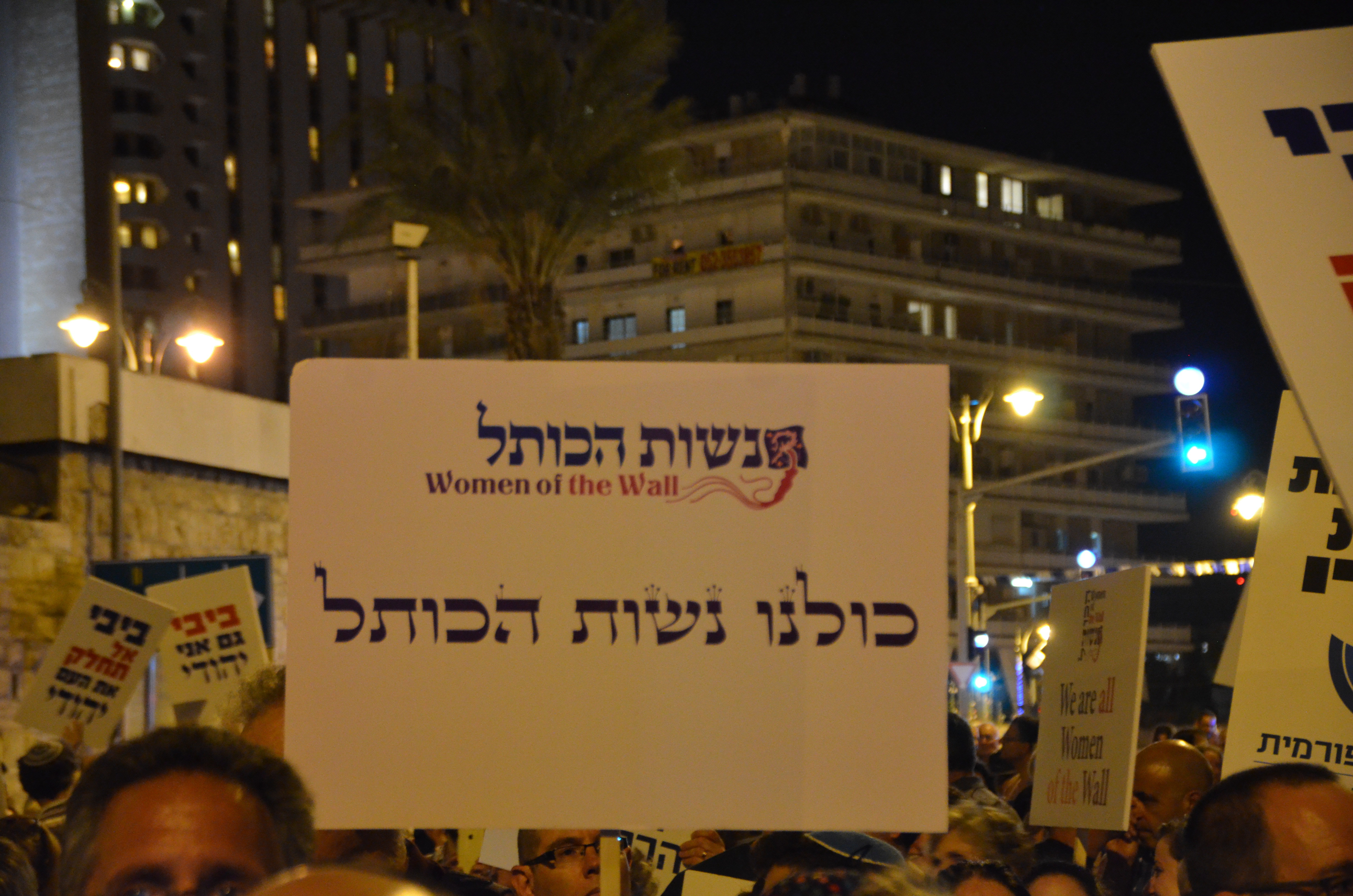 שלט "כולנו נשות הכותל" בהפגנה נגד כפייה חרדית