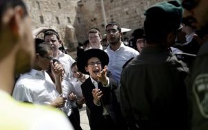 A group of Jewish ultra-Orthodox men and boys oppose the prayer service of the Women of the Wall